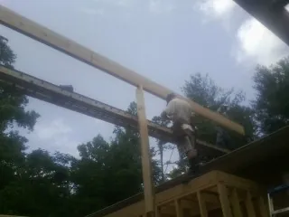 Carpenter setting a ridge beam over a new addition frame — Ice Dam Removal by Roofing Brothers in Hooven