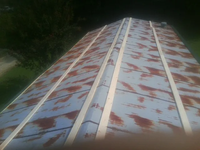Rusted metal roof panels with new wood purlins before replacement — Storm Damage Roof Repair in Hooven by Roofing Brothers