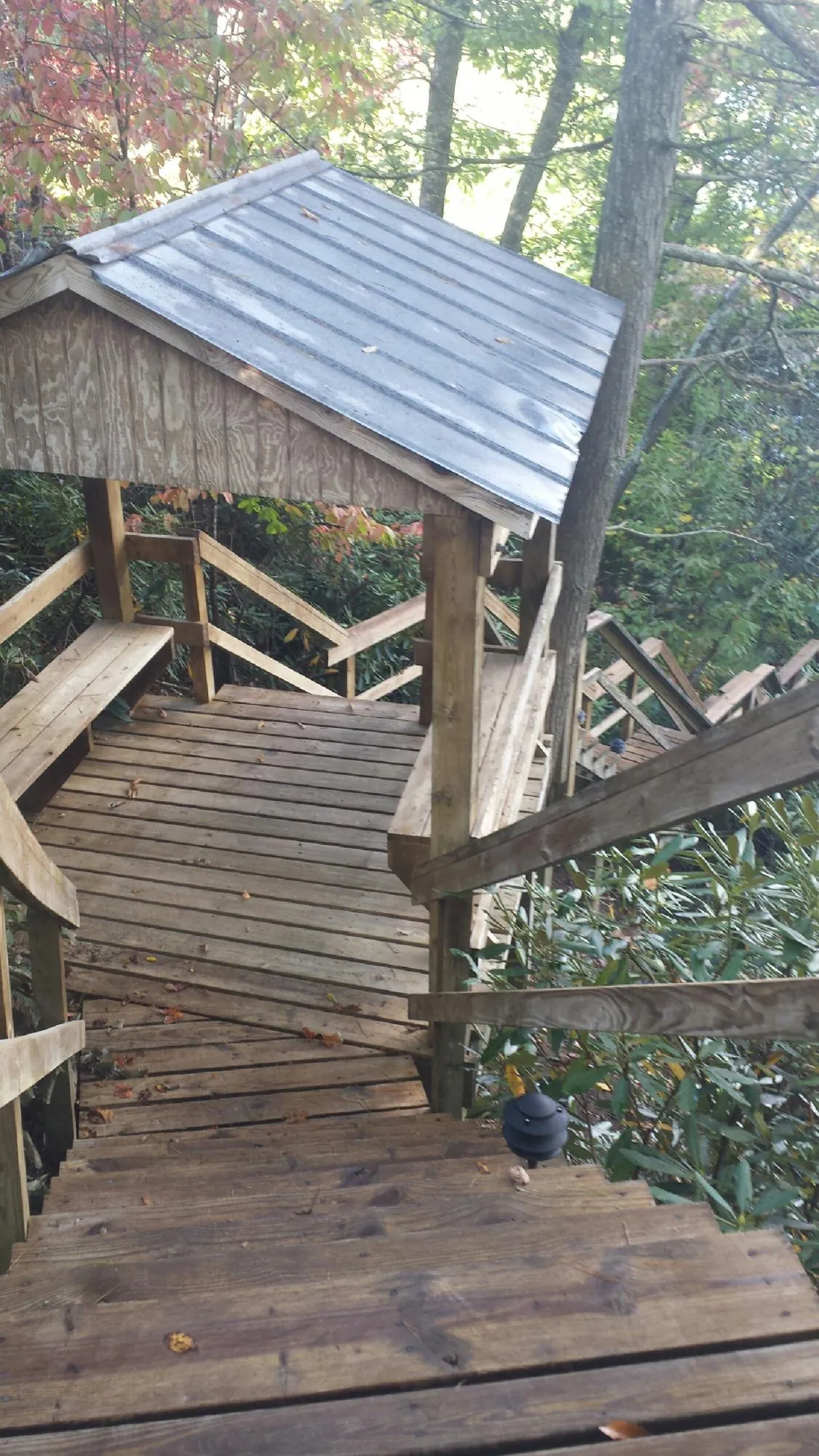 Metal roofed shelter over wooden steps on a wooded walkway — Skylight Repair & Installation work by our crew in Hooven