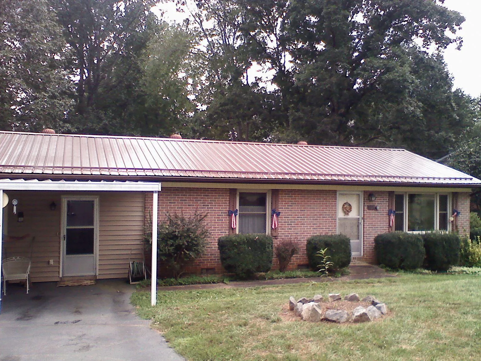 Bronze metal roof and carport on a brick ranch home — Roof Repair work by our crew in Hooven
